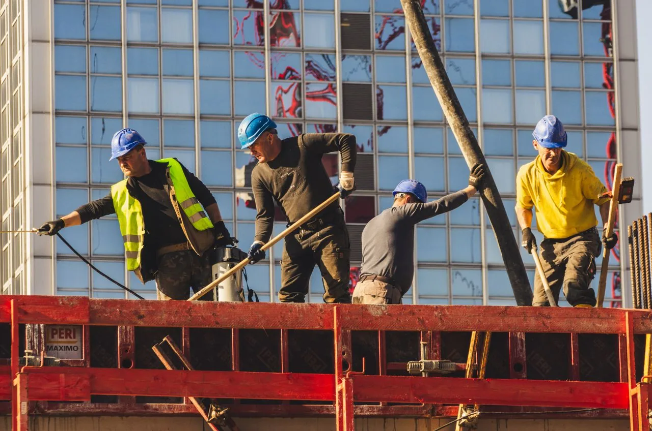 Equipe de operários trabalhando na fôrma da laje em obra predial — mão de obra CLT da Shark Construtora em Curitiba