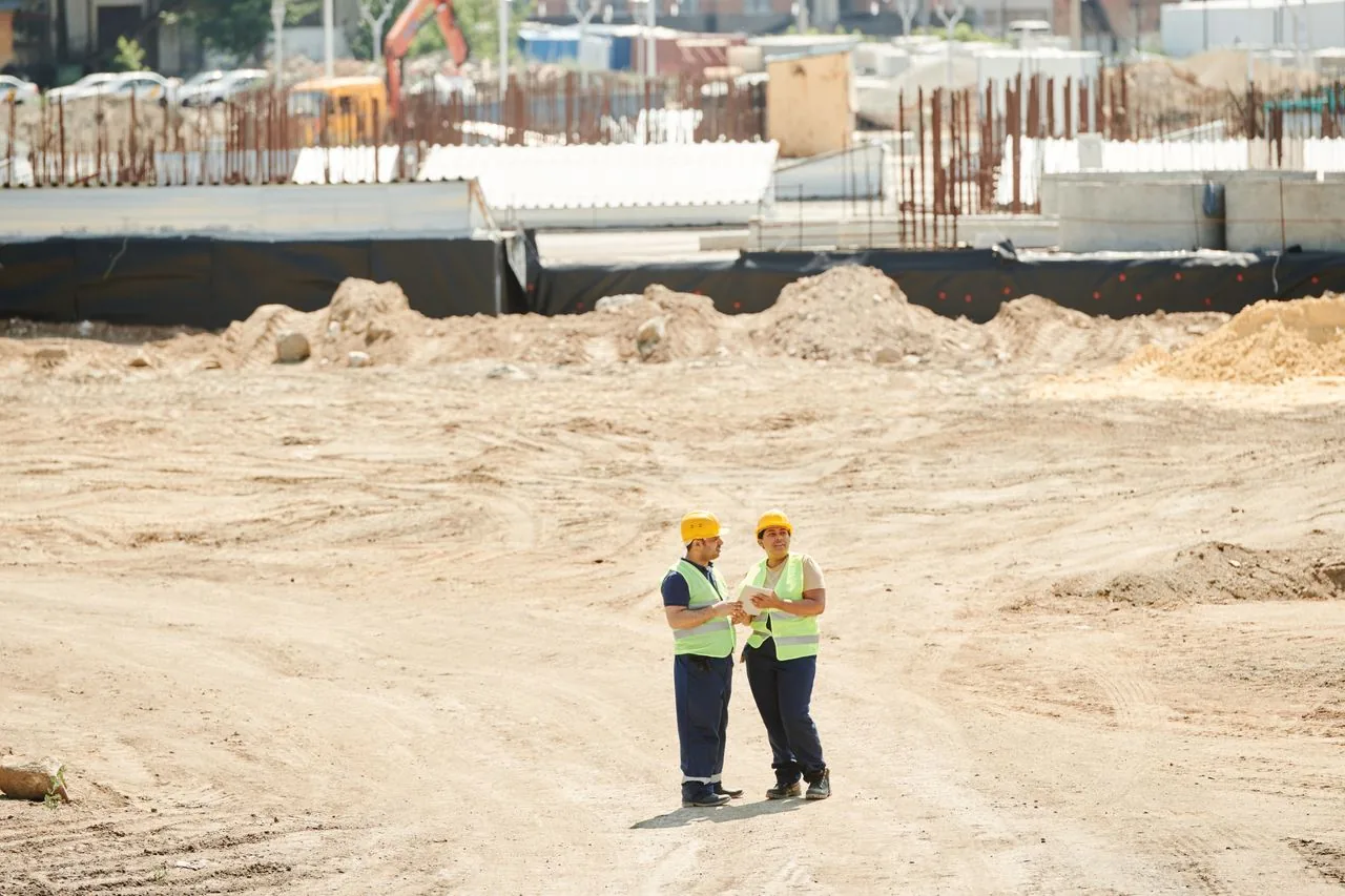 Dois profissionais de obra planejando o cronograma no canteiro, gestão de equipe da Shark Construtora